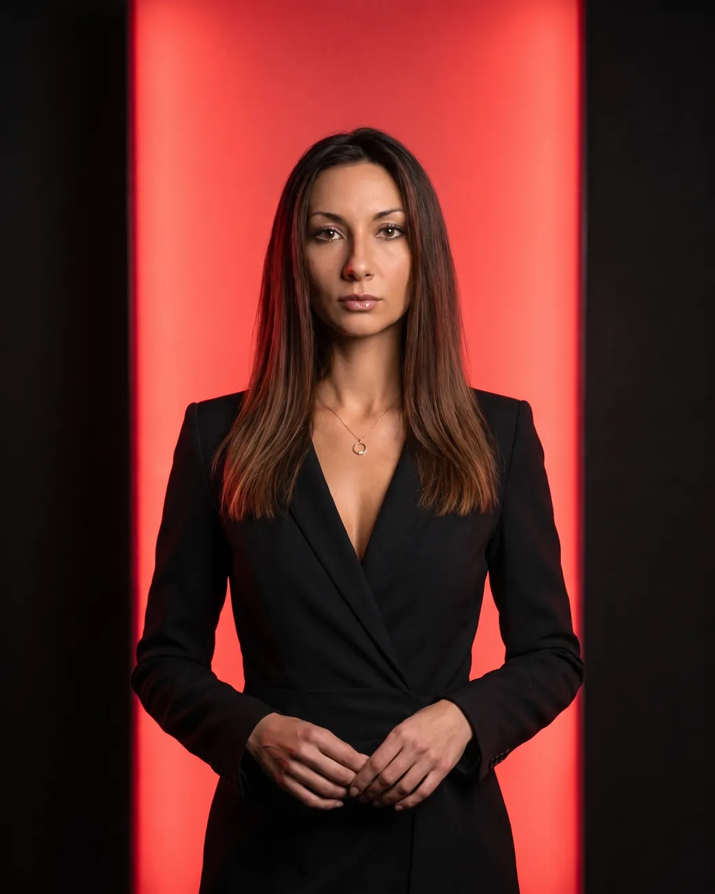 Marija, standing in front of a lit red panel.